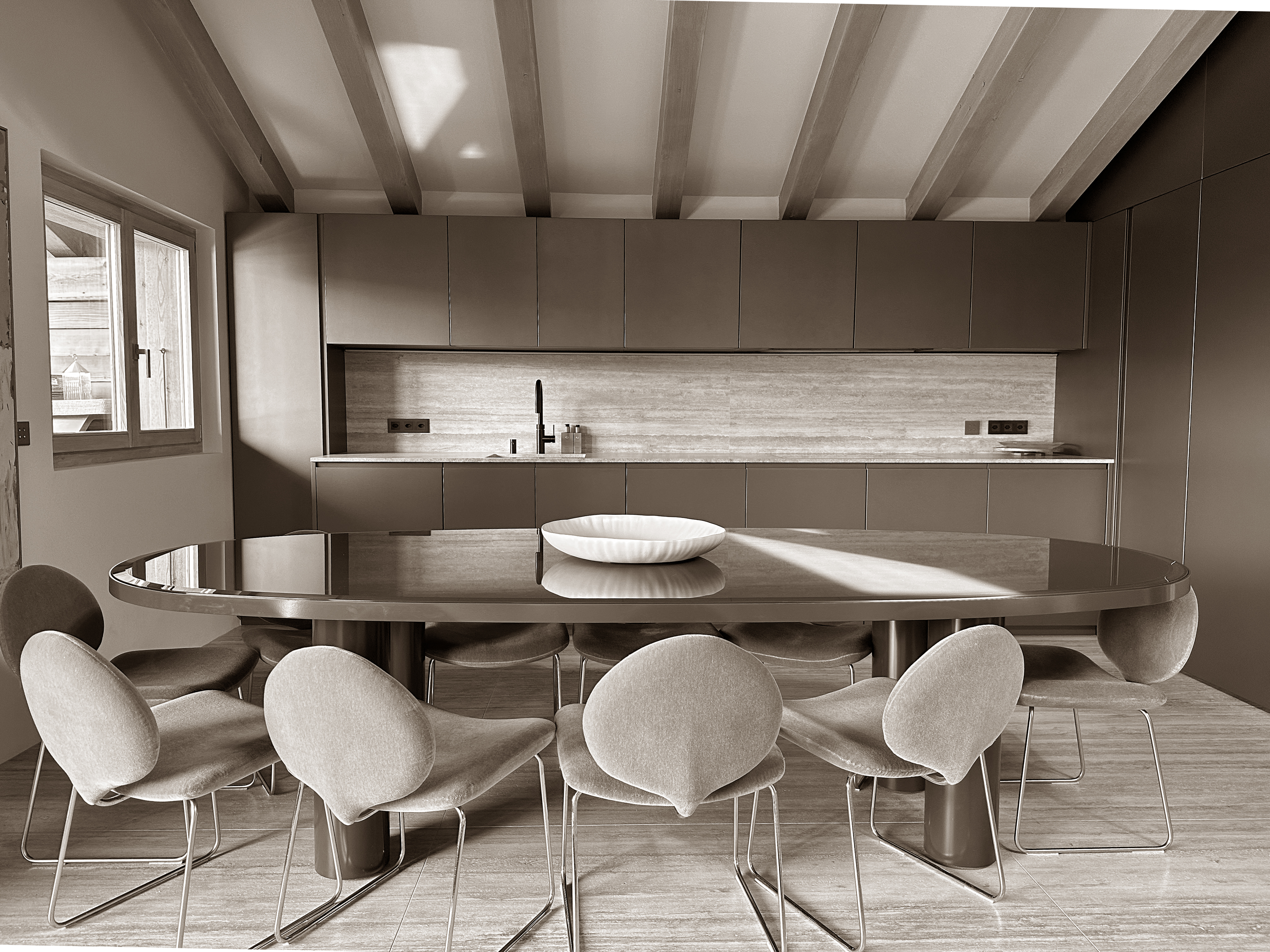 Sophisticated open-plan kitchen and dining area featuring sleek, minimalist cabinetry and a striking oval dining table surrounded by sculptural chairs. The soft neutral palette, exposed beams, and natural light create a refined yet welcoming atmosphere, perfect for stylish gatherings. Sophisticated open-plan kitchen and dining area featuring sleek, minimalist cabinetry and a striking oval dining table surrounded by sculptural chairs. The soft neutral palette, exposed beams, and natural light create a refined yet welcoming atmosphere, perfect for stylish gatherings.