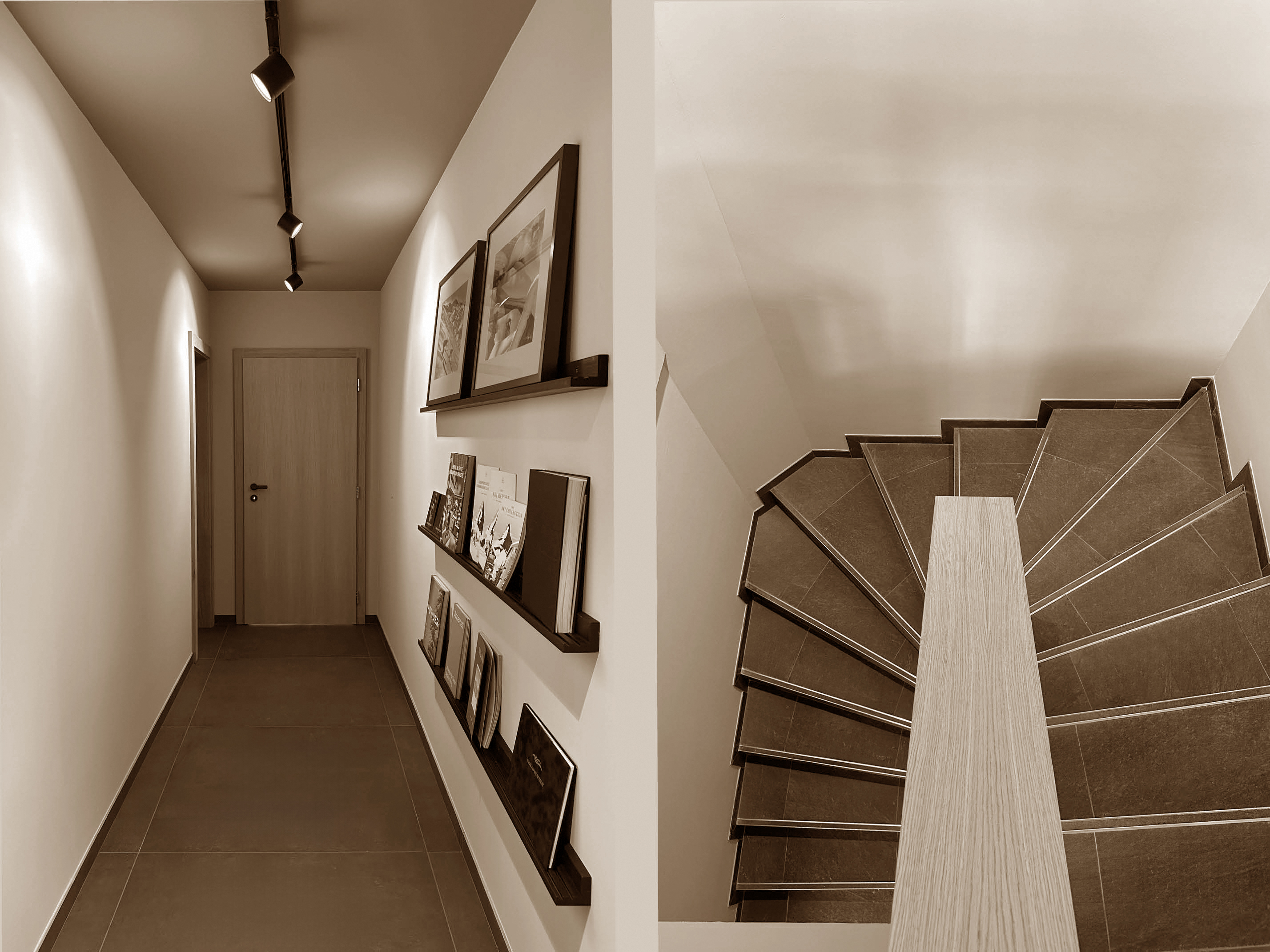 A sleek hallway and sculptural staircase blend clean lines with warm tones, creating a minimalist, gallery-like ambiance throughout the space.