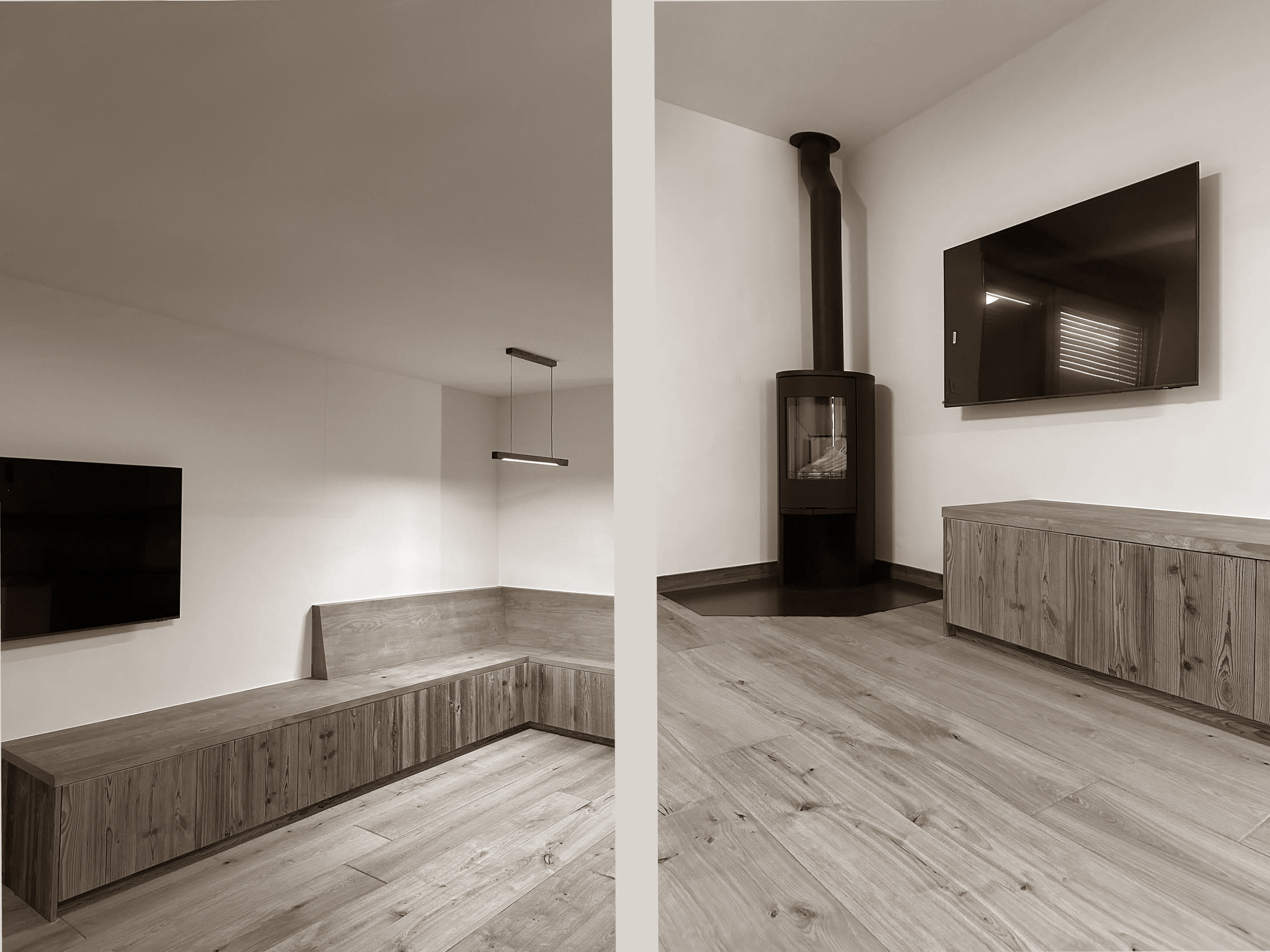 Minimalist living area featuring clean-lined wooden cabinetry, a wall-mounted television, and a sleek wood-burning stove tucked into the corner. The natural flooring and integrated bench seating bring warmth and functionality to this modern, uncluttered alpine retreat.