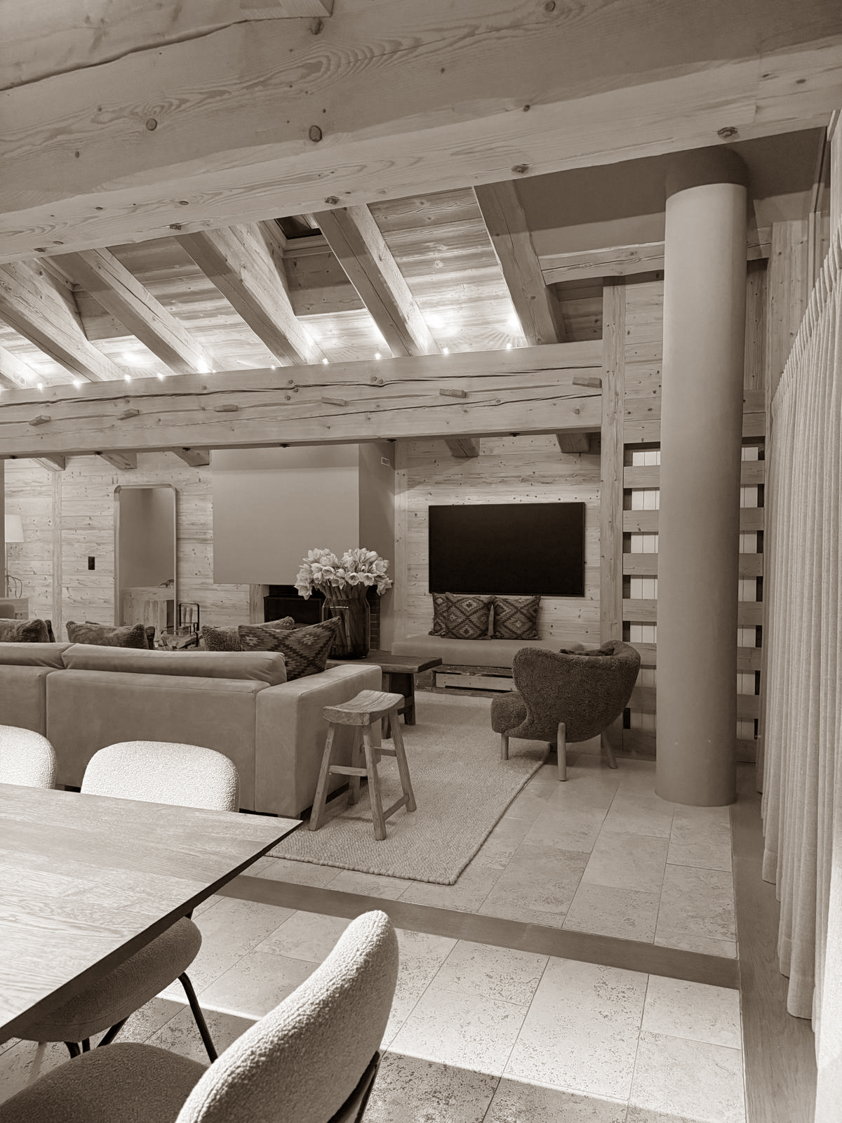 Exposed beams and soft lighting bring warmth and volume to this inviting alpine living room.