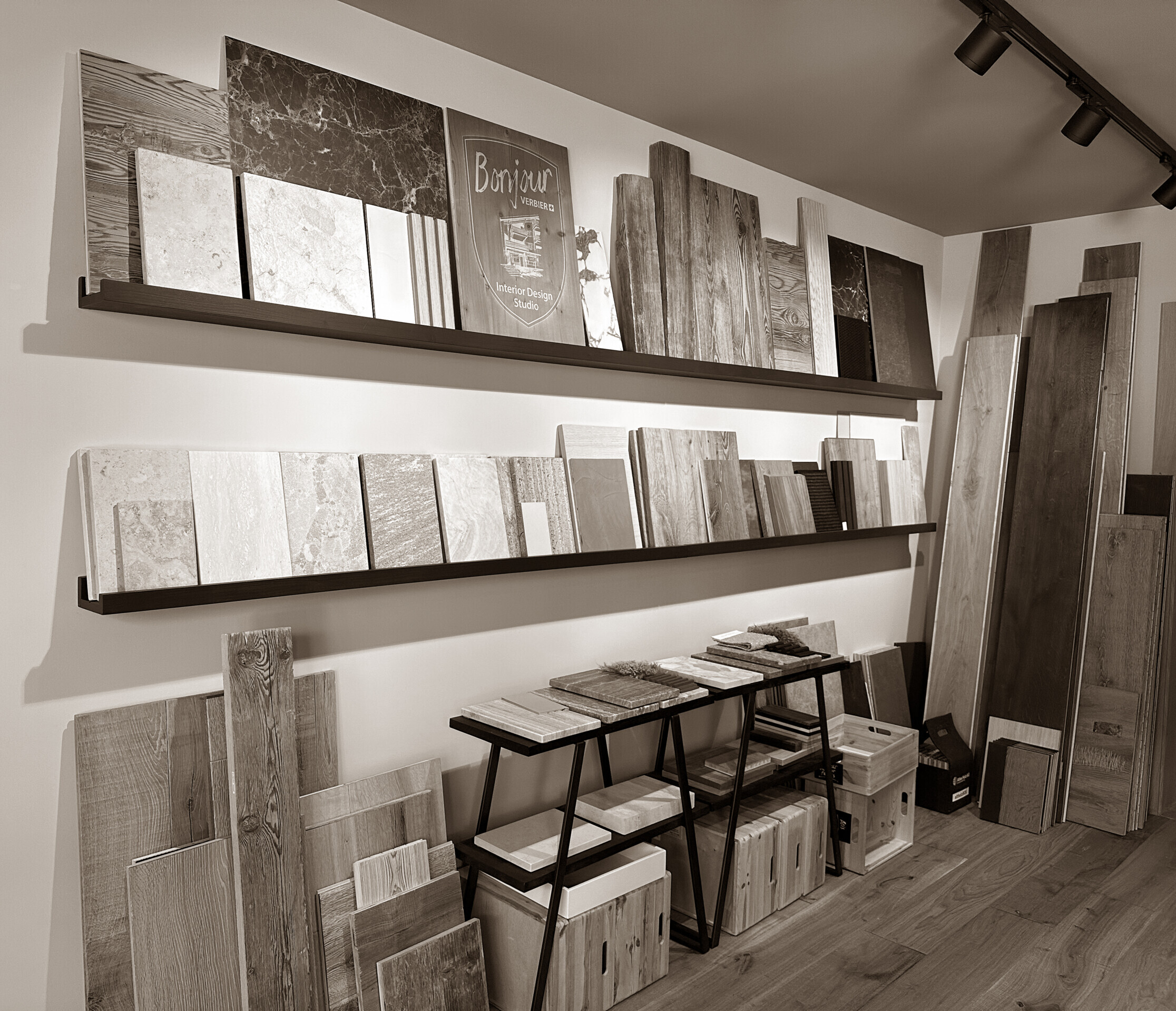 A refined materials library where wood, stone, and tile samples line the walls - an elegant space for imagining and shaping bespoke alpine interiors