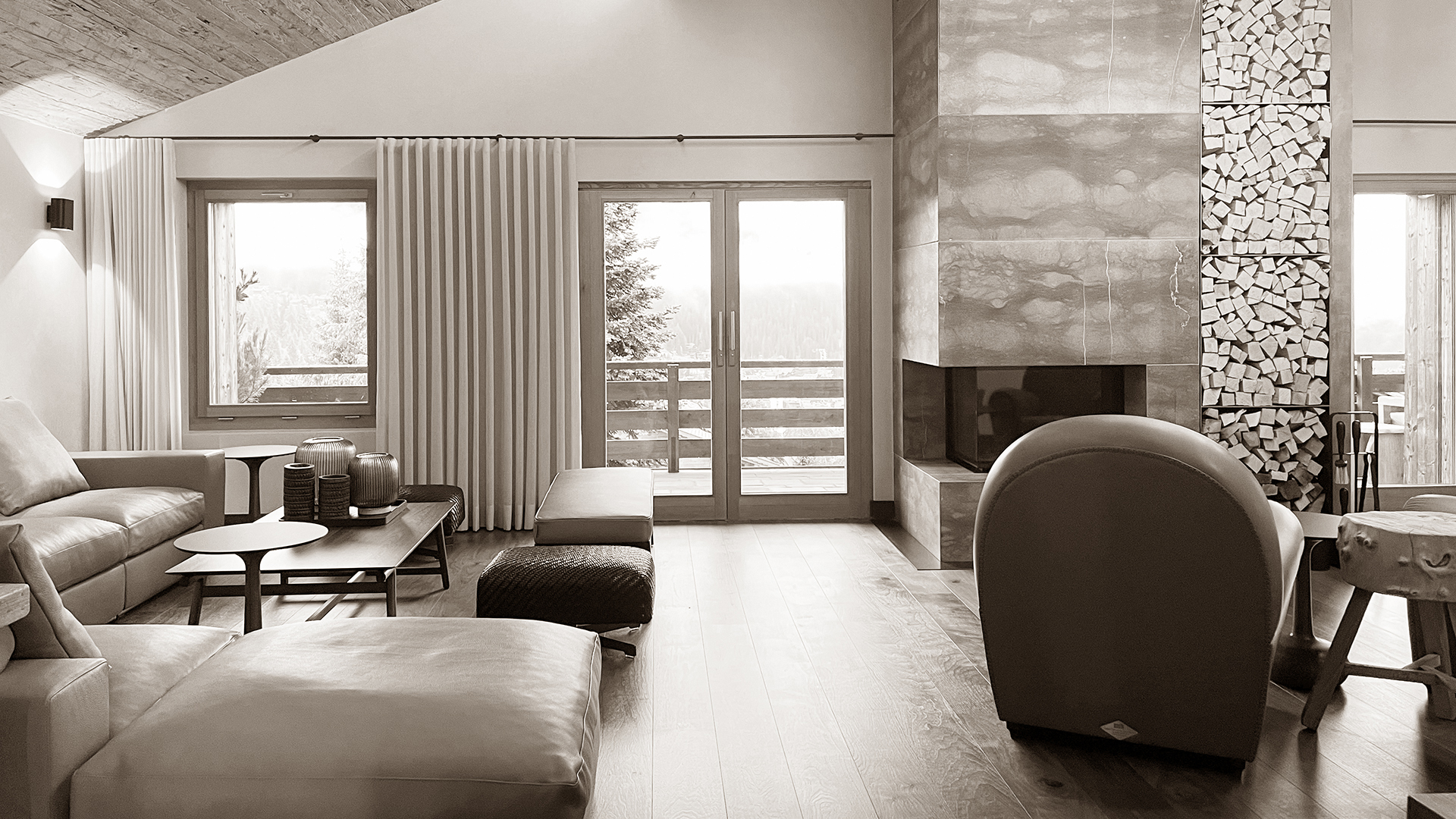 Cozy sofa corner in the living room of Chalet Harmony, featuring plush leather seating, a contemporary coffee table, and a modern fireplace, creating a warm and inviting atmosphere for relaxation.