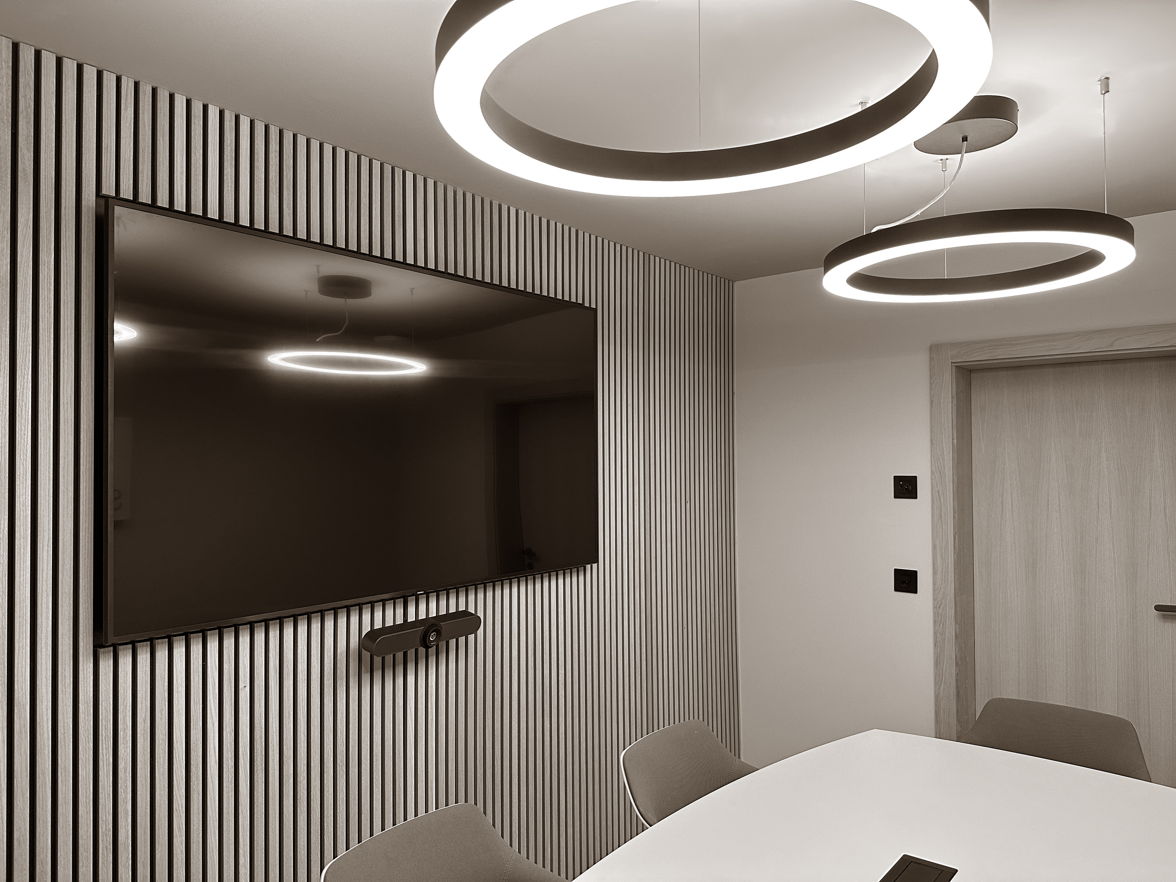 A modern meeting room featuring sculptural lighting, clean lines, and a sleek, professional atmosphere.