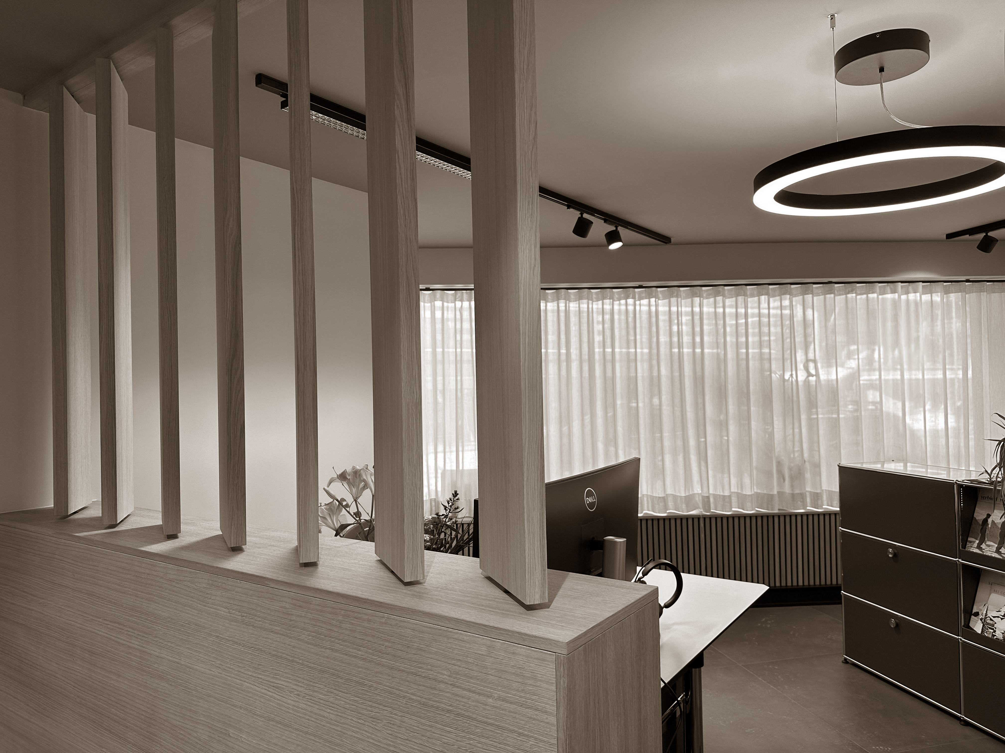 Vertical slats create subtle division and rhythm, while the soft glow from modern lighting keeps the space open and contemporary.