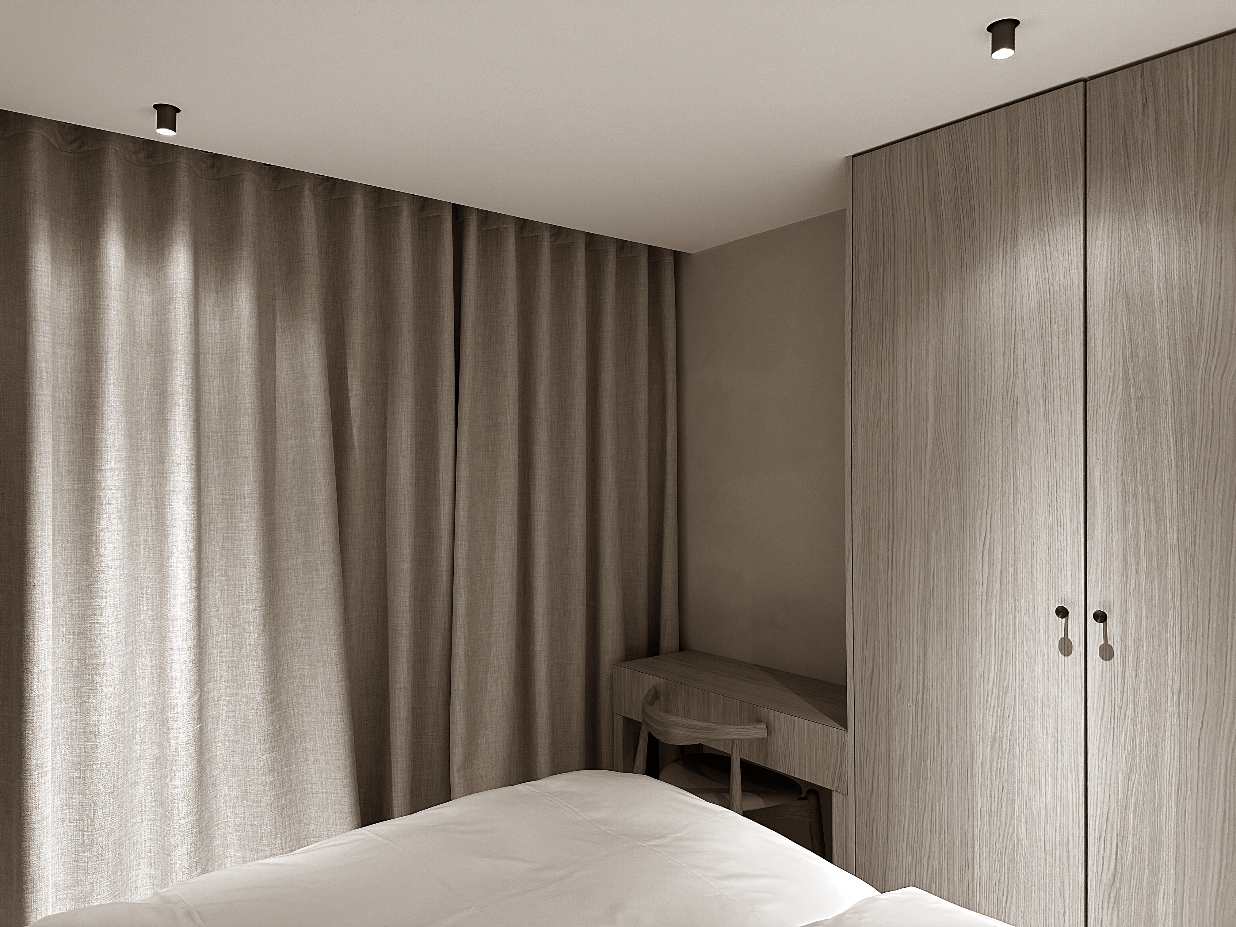Soft curtains and built-in woodwork create a peaceful, cocoon-like atmosphere in this quiet bedroom corner.