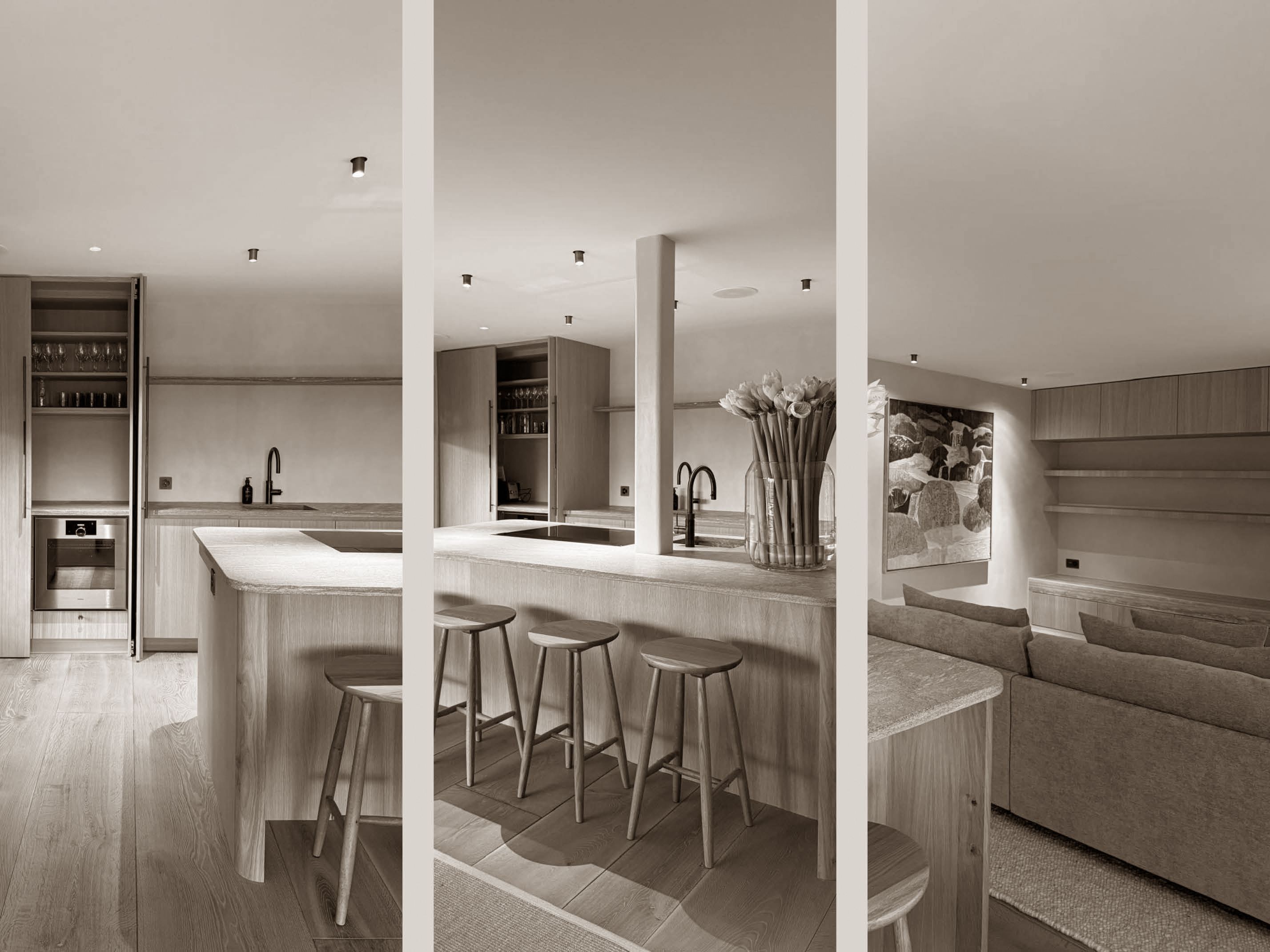 Refined and harmonious living space where the kitchen, dining, and lounge areas merge seamlessly. The pale wood cabinetry and stone surfaces are paired with minimalist black fixtures and understated furnishings, offering a serene and stylish environment that celebrates simplicity and comfort.