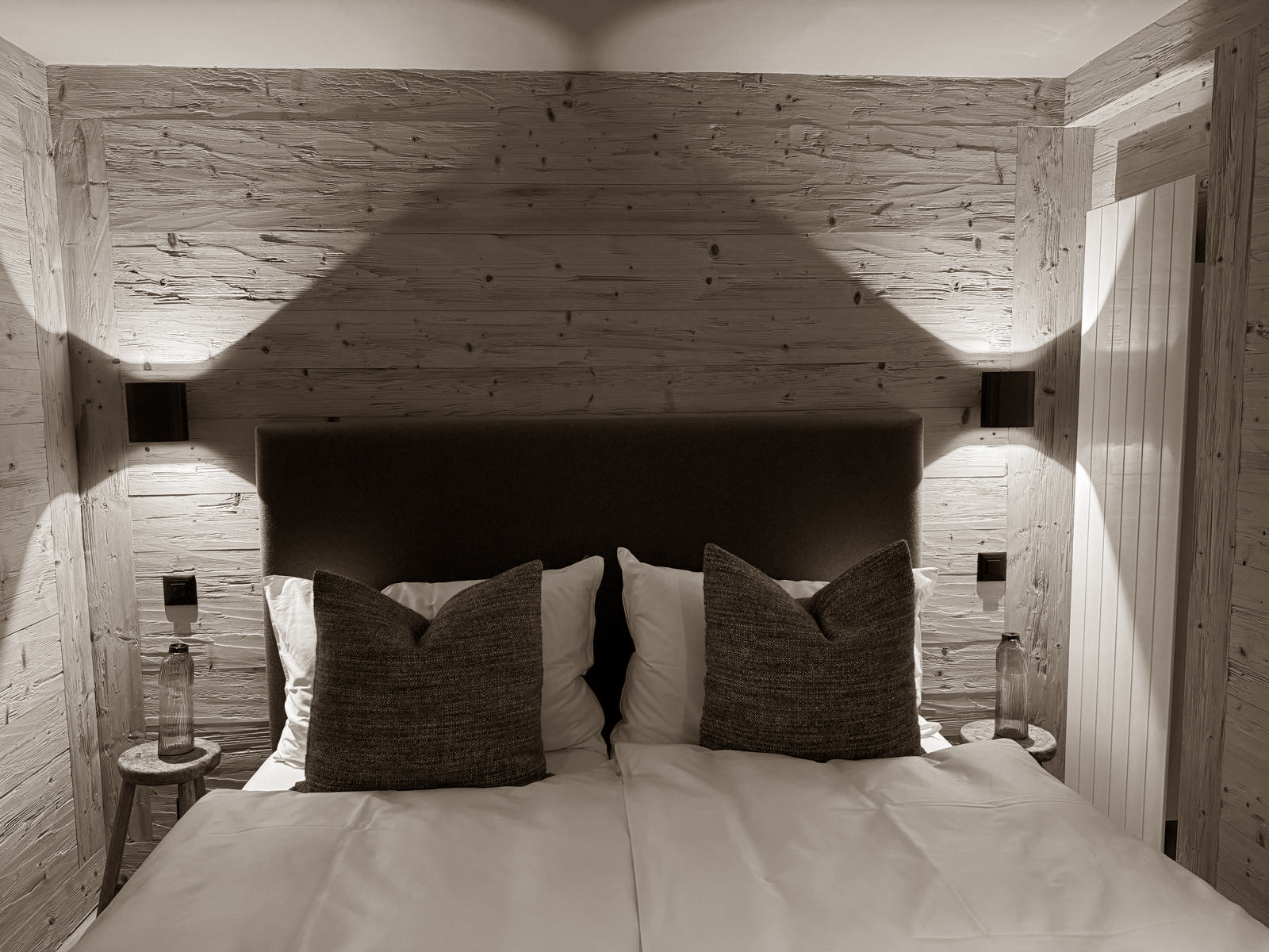 Textured timber walls and soft lighting create a warm, cocoon-like atmosphere in this inviting bedroom retreat.