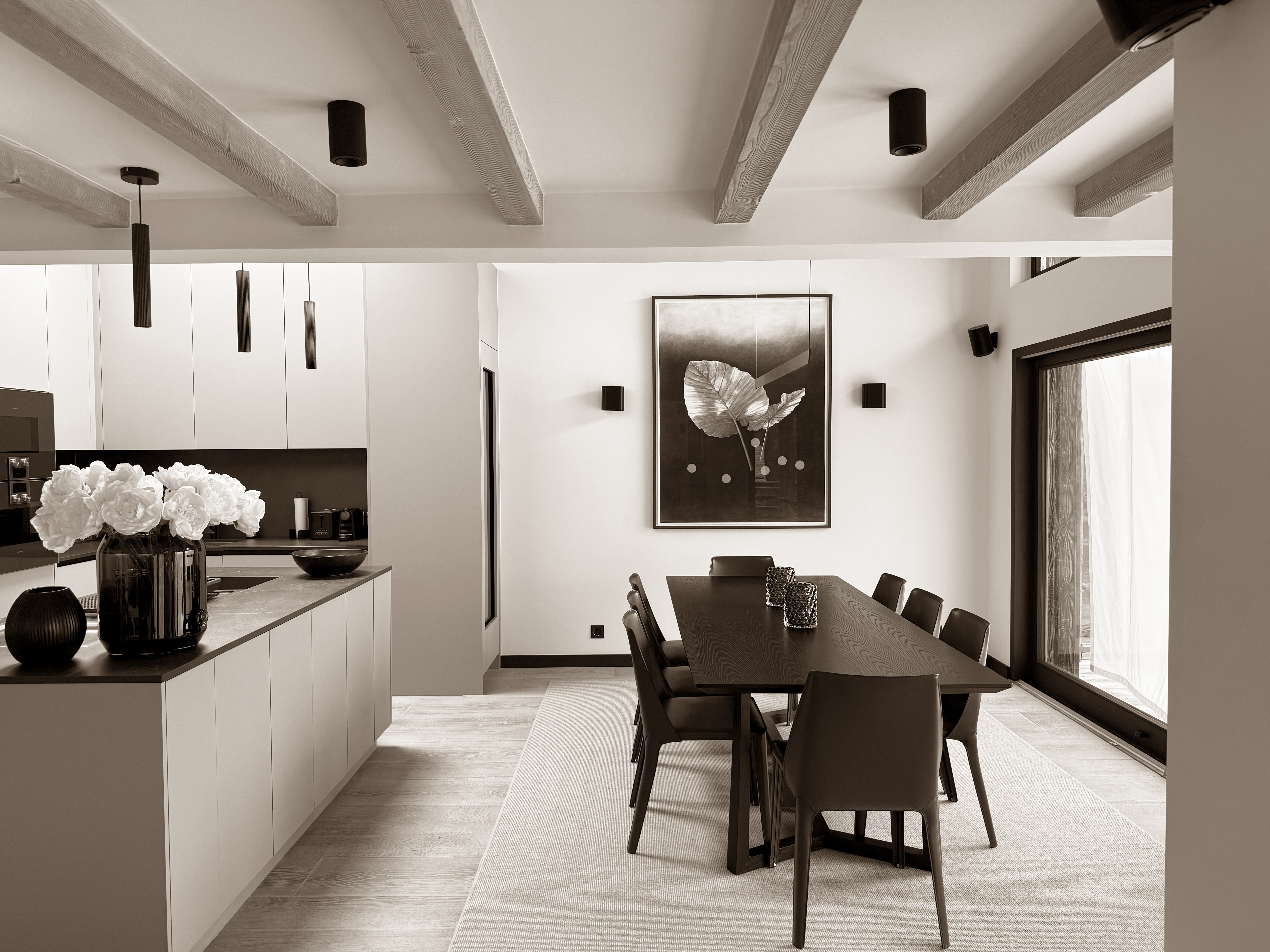 Elegant dining area in Chalet Beauty, featuring a sleek modern table, designer chairs, and refined decor with floral accents, blending minimalist architecture with cozy touches to create a stylish and inviting space for shared moments.